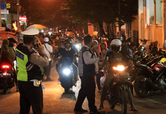 KEWALAHAN: Petugas Dishub Kota Pasuruan dan Satlantas Polres Pasuruan Kota menghalau pengendara yang melanggar rambu larangan di Jalan Sumatera. (Foto: Mokhamad Zubaidillah/Jawa Pos Radar Bromo)