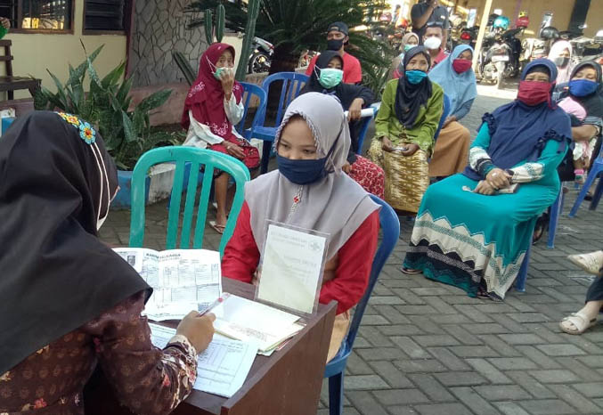 ANTRE: Beberapa warga mengantre untuk penyuntikan vaksin di Puskesmas Pakuniran. Hingga kini tersisa 30 ribu dosis vaksin untuk disuntikkan pada tahap kedua. (Foto: Jamaludin/Jawa Pos Radar Bromo)