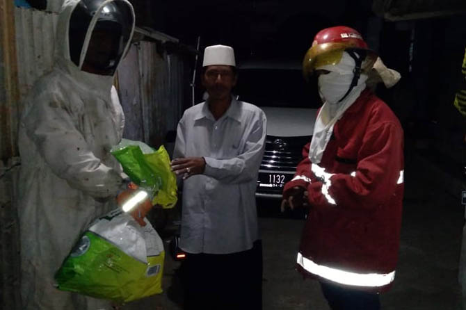 EVAKUASI: Petugas Damkar Kabupaten Probolinggo mengevakuasi sarang tawon vespa di rumah Zainul, warga Desa Banjarsari, Selasa (1/6) malam. (Pemadam Kebakaran For Jawa Pos Radar Bromo)