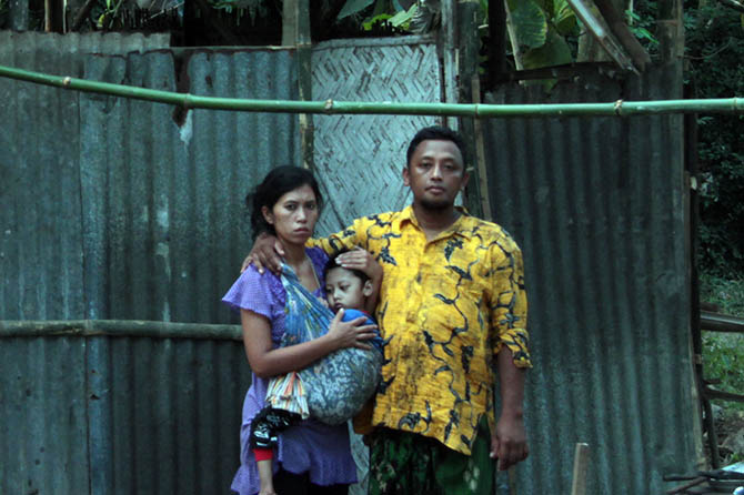 KEKURANGAN: Solehudin bersama istri dan anak yang alami gizi buruk, di depan rumahnya. (Agus Faiz Musleh/Radar Bromo)