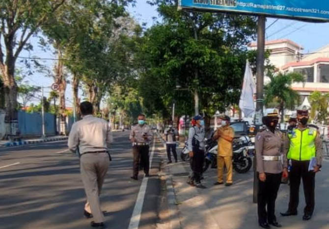 PASTIKAN AMAN: Tim Ditlantas Polda Jatim dan Satlantas Polres Pasuruan Kota melihat kondisi KTL Jalan Pahlawan. (Satlantas Polres Pasuruan Kota for Jawa Pos Radar Bromo)