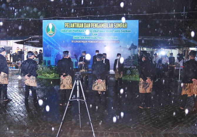 DERAS: Hujan yang mengguyur saat pelantikan pejabat di Pasar Gadingrejo, Sabtu (12/6) malam. (Foto M Busthomi/Jawa Pos Radar Bromo)