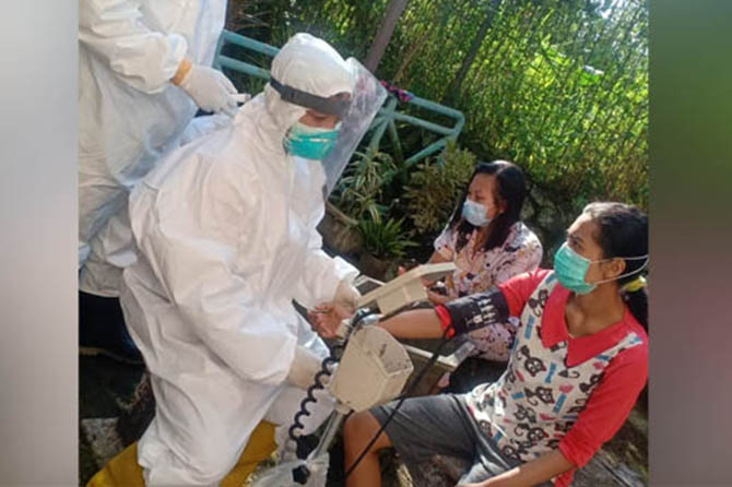 RUMAH KARANTINA: Petugas saat memeriksa penghuni rumah karantina di Hotel Permata Biru Prigen. (Istimewa)