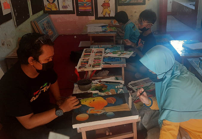 SENI: Iron Supali saat mengajar melukis. (Foto: Fahrizal Firmani/Jawa Pos Radar Bromo)