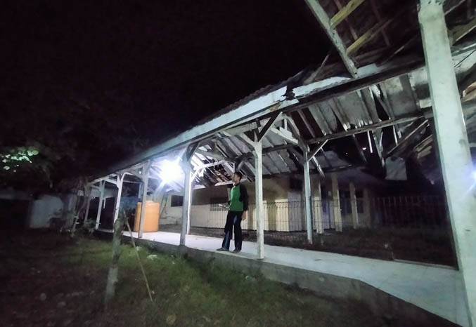 PANTAU ASET: Seorang penjaga memantau kawasan gedung eks RSUD Bangil, Kabupaten Pasuruan, untuk memastikan aset daerah itu aman. (Foto: Iwan Andrik/Jawa Pos Radar Bromo)