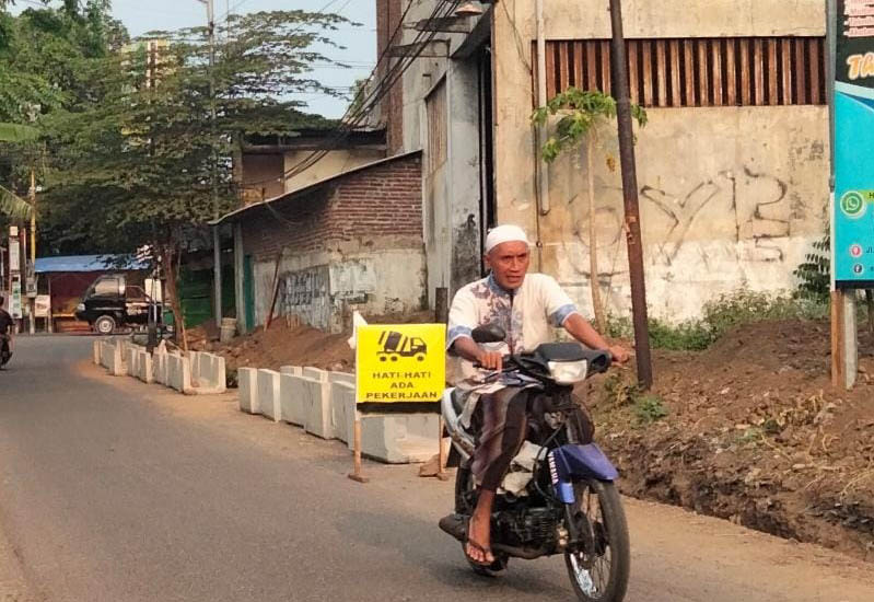 DIBENAHI: Pemotor melintas di Jalan Supriyadi yang mulai diperbaiki. (Foto M Busthomi/Jawa Pos Radar Bromo)
