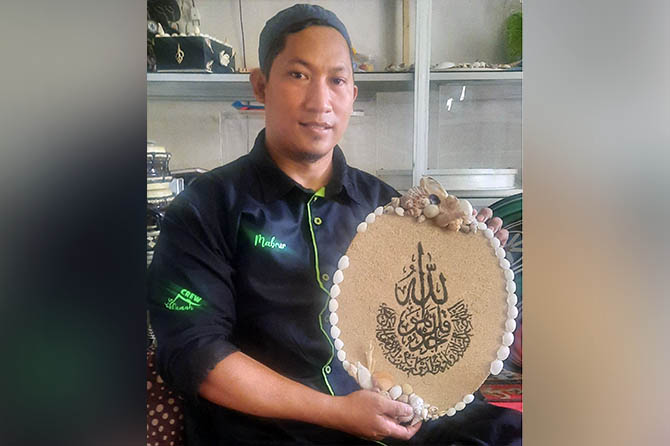 KREATIF: Mochammad Mabrur dengan karya kaligrafi dari pasir laut kreasinya. (Foto: Fahrizal Firmani/Jawa Pos Radar Bromo)