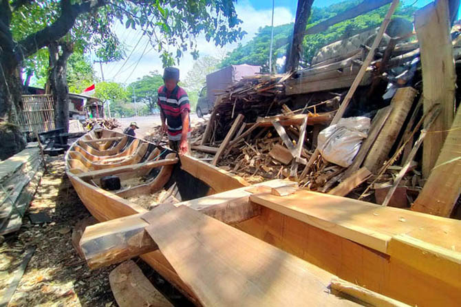 TURUN-TEMURUN: Sali saat mengerjakan perahu pesanan. (Foto: Iwan Andrik/Jawa Pos Radar Bromo)