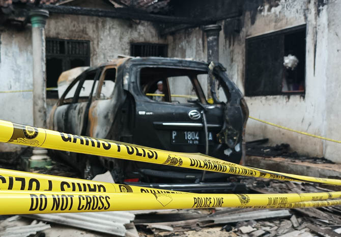 DISELIDIKI: Mobil milik Saiful usai terbakar di garasi rumahnya. Insiden ini diselidiki polisi dan di lokasi terpasang police libe. (Foto: Agus Faiz Musleh/Jawa Pos Radar Bromo)