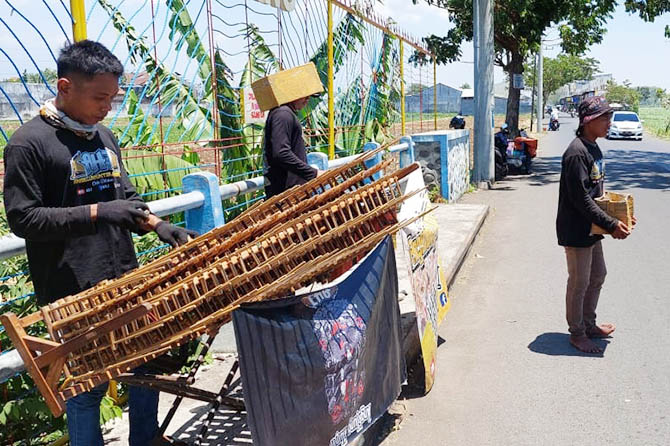 MENGAMEN: Angklung Hunter Jember saat mengamen di simpang empat Jalan Abdurrahman Wahid. (Rizky Putra Dinasti/Jawa Pos Radar Bromo)