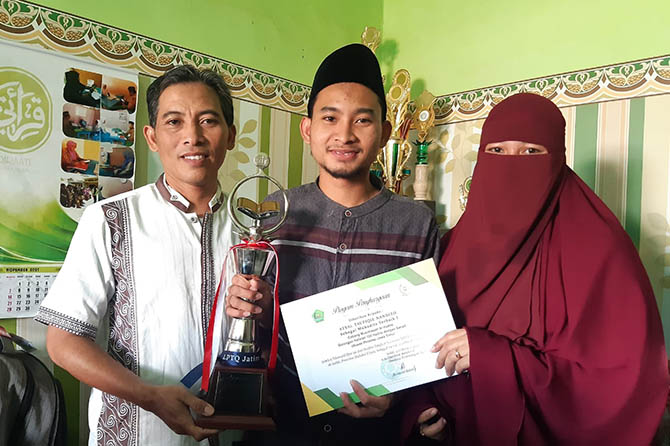SANTRI: Atsal diapit Irfan Suhardianto dan Husnawiyah dengan membawa trofi juara satu. (Foto: Arif Mashudi/Jawa Pos Radar Bromo)