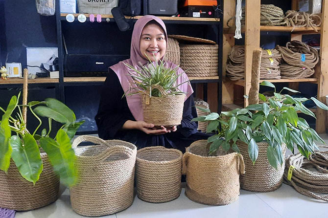 KREATIF: Dennyk Septyandini dan pot tanaman yang dihias tali rami buatannya. (Foto: Fahrizal Firmani/Jawa Pos Radar Bromo)