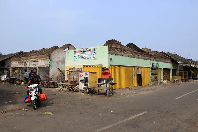 SEGERA DIPERBAIKI: Pengendara motor melintas di depan Pasar Nguling, Kabupaten Pasuruan, yang terbakar, Kamis (7/10) lalu. Pasar ini direncanakan diperbaiki tahun depan. (Mokhamad Zubaidillah/Radar Bromo)