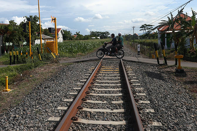 BERMASALAH: Pemotor melintas di perlintasan KA di Jalan Sunan Muria, Kelurahan Kebonsari Wetan, Kecamatan Kanigaran, Sabtu (6/11). (Zainal Arifin/Radar Bromo)