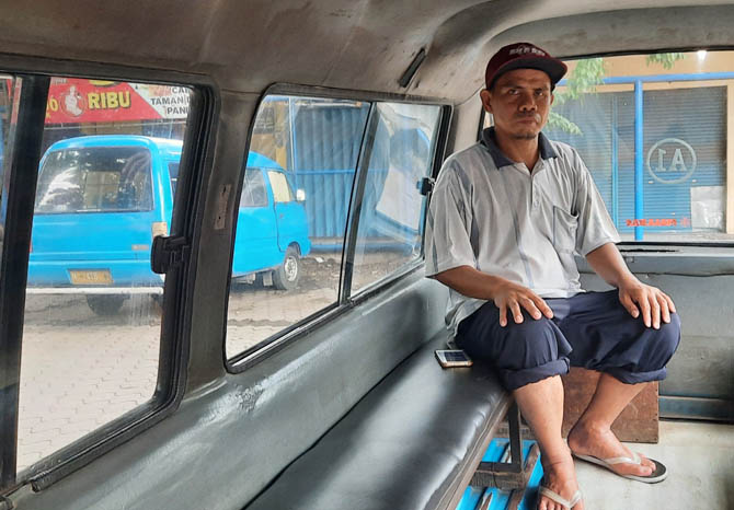 TUNGGU REZEKI: Suyitno sopir angkot line A1 berdiam di dalam angkotnya yang standby di Sub Terminal Kebonagung. (Foto: Fahrizal Firmani/Jawa Pos Radar Bromo)