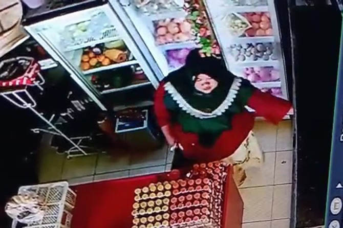 GONDOL TAS: Perempuan bertubuh subur menggondol tas di salah satu toko buah di Pasar Kebonagung, Kota Pasuruan, Sabtu (27/11). (Foto: Repro Jawa Pos Radar Bromo)