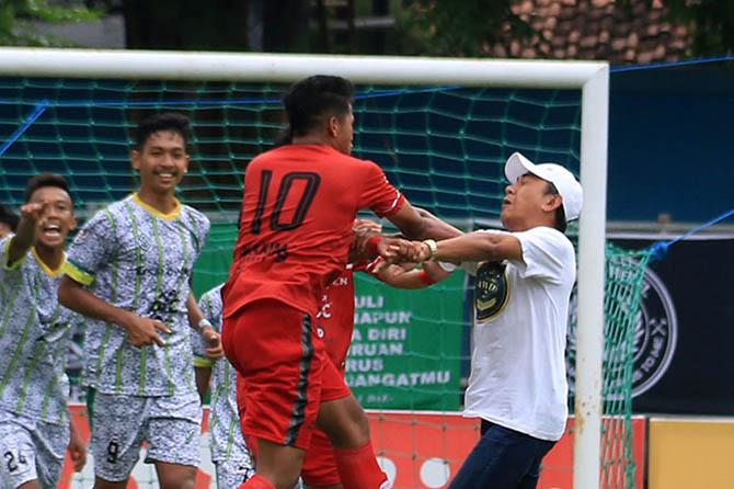 RICUH USAI LAGA: Kapten AFA Syailendra Ilham Wibisono saat melepaskan bogem ke Ketua DPRD Kota Pasuruan Ismail Marzuki yang masuk lapangan usai laga. (Mokhamad Zubaidillah/Radar Bromo)