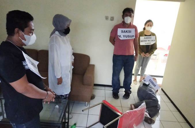TANPA PENYESALAN: Tersangka Deni Wahyudi (baju hitam) melihat orang yang memeragakan M Nurwanto. (Foto: Rizal F Syatori/Jawa Pos Radar Bromo)