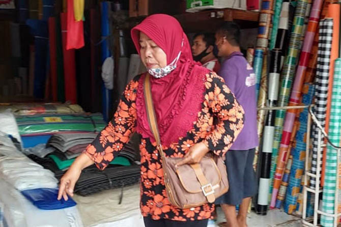 KEBINGUNGAN: Yati di salah satu toko di sekitar Pasar Baru. Kemarin dia baru membeli kasur, tapi malah dibawa tukang becak motor. (Foto: Rizky Putra Dinasti/Jawa Pos Radar Bromo)