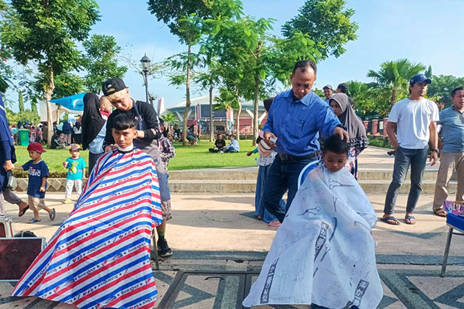 ANTRE: Sejumlah warga antre potong rambut di halaman GOR Untung Suropati Kota Pasuruan. Mereka berpartisipasi dalam kegiatan amal menghimpun donasi untuk korban erupsi Semeru. (Foto M Busthomi/Radar Bromo)