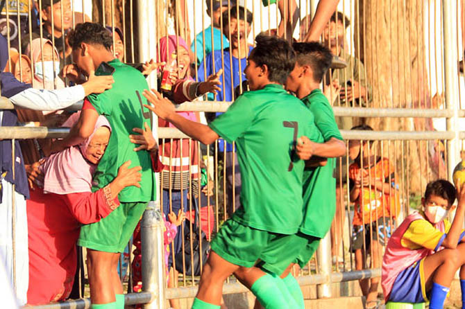 DUKUNGAN IBU: Kapten Persekap Jr Fran Adi memeluk ibunya dari celah pagar lapangan setelah menyarangkan penalti kedua ke gawang Arema FC, kemarin (22/12) di Stadion Untung Suropati Kota Pasuruan. Persekap Jr pun lolos dari putaran awal Piala Soeratin U-17