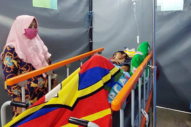 DIRAWAT: Sugiono ditemani Sana menjalani perawatan di IGD RSUD dr. Mohamad Saleh, Kota Probolinggo, Sabtu (1/1). (Foto: Rizky Putra Dinasti/Radar Bromo)