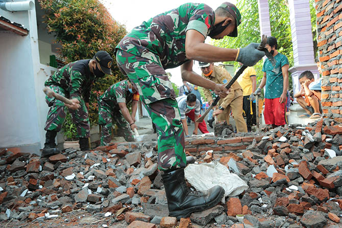 DIJEBOL: Sejumlah anggota TNI bersama warga membongkar tombok pembatas RT 2 dan RT 3/RT 6, Kelurahan Mangunharjo, Kecamatan Mayangan, Senin (24/1). (Humas Pemkot Probolinggo for Jawa Pos Radar Bromo)