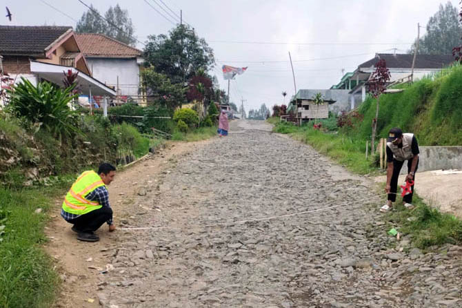 SUDAH DISURVEI: Petugas dari Dinas PU PR mengukur Jalan di Ledokombo. Jalan ini rencananya bakal dibenahi. (Foto: Dinas PUPR for Jawa Pos Radar Bromo)