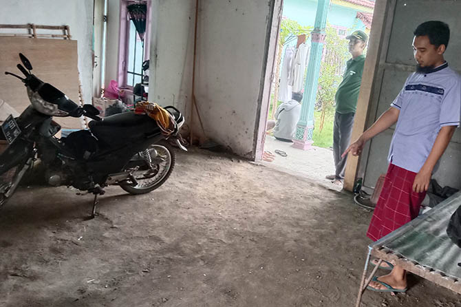 HILANG: Korban Muhammad Fatlullah menunjukkan posisi terakhir tiga motornya di garasi. (Achmad Arianto/Radar Bromo)