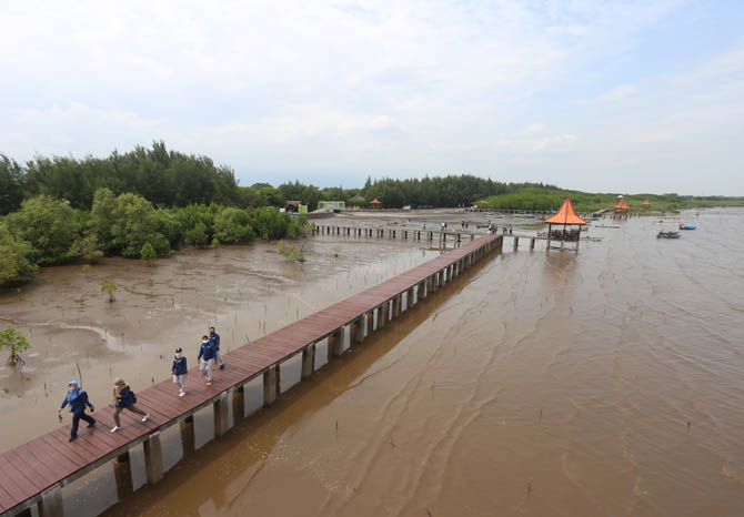 PENUNJANG PENDAPATAN: Wisatawan berjalan di board walk Pantai Bahak kemarin. Destinasi wisata ini ditarget bisa menyumbang pemasukan ke daerah mulai tahun 2022. (Foto: Zaenal Arifin/Jawa Pos Radar Bromo)