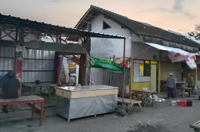 BERHARAP PEMBANGUNAN: Pedagang di Pasar Nguling yang menjadi korban kebakaran berjualan di lapak. (Foto: Dok. Radar Bromo)