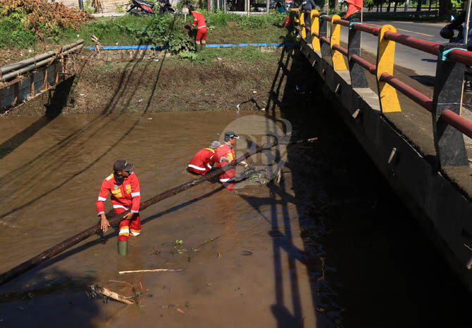 LANGSUNG TERJUN: Petugas membersihkan sampah di kali Petung, pagi kemarin. Dinas PU PR meniagakan personelnya selama penghujan untuk memantau debit sungai. (Foto: M Zubaidillah/Jawa Pos Radar Bromo)