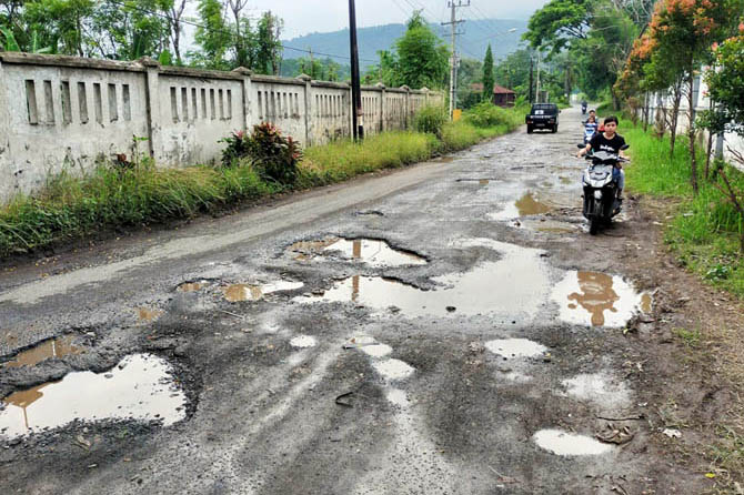 PERLU DIBENAHI: Aspal banyak berlubang di ruas jalan kabupaten tepatnya di Dusun Genting, Desa Sukolilo, Kecamatan Prigen. (Foto: Rizal Fahmi Syatori/Jawa Pos Radar Bromo)