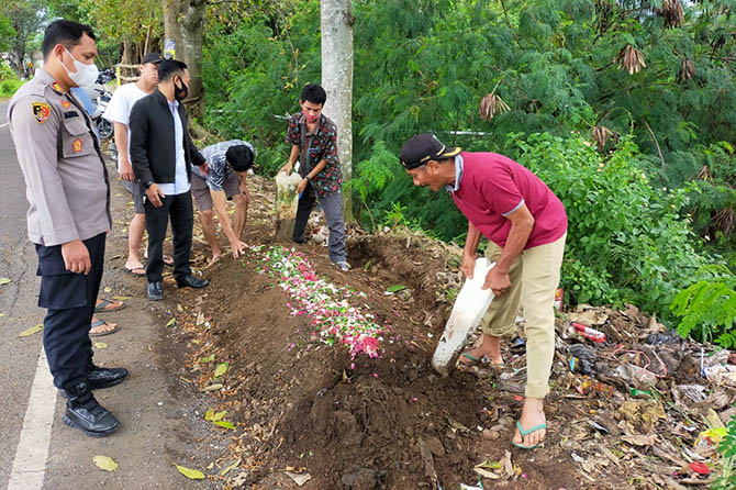 BIKIN HEBOH: Warga dan petugas saat membongkar makam di tepi jalan yang muncul mendadak dan bikin heboh. (Rizal Syatori/Radar Bromo)