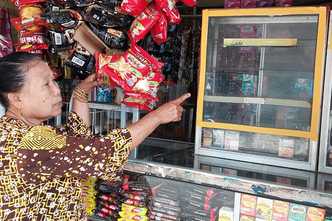 LUDES: Aliyah menunjukkan etalase tempatnya menyimpan rokok. Etalase ini telah kosong setelah isinya digondol maling, Senin (31/1). (Rizky Putra Dinasti/Jawa Pos Radar Bromo)