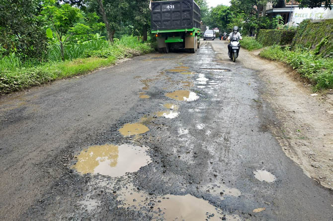 BERTEBARAN: Lubang aspal di Jalan Raya Ngembal segera diperbaiki. (Foto: Rizal F Syatori/Radar Bromo)