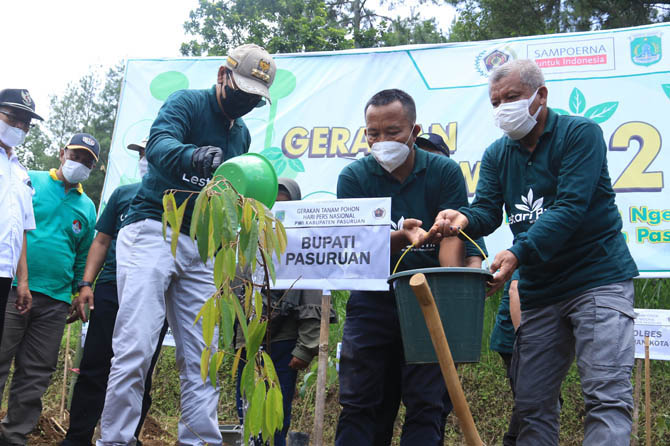 JAGA BUMI KITA: Bupati Irsyad Yusuf menyiram bibit pohon bersama Ketua PWI Pasuruan Joko Haryanto di lereng Gunung Bromo, kawasan Ngembal, Kecamatan Tutur, Rabu (23/2) pagi. (Foto: M Zubaidillah/Jawa Pos Radar Bromo)