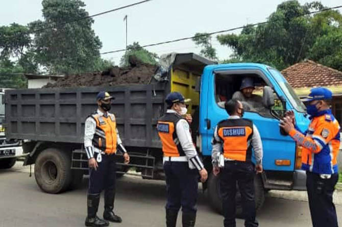 DITEGUR: Salah seorang sopir truk tambang ditegur petugas Dishub Kabupaten Probolinggo, karena tidak menutup muatannya yang berupa tanah uruk, Sabtu (12/3). (Dishub for Radar Bromo)