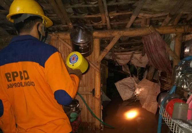 TERGENANG: Personel BPBD memantau kondisi banjir di Desa Asembagus, Kecamatan Kraksaan. Banjir terjadi usai hujan mengguyur sejak Senin (14/3)sore. (Foto: BPBD for Jawa Pos Radar Bromo)