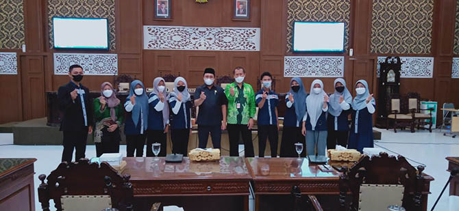 FOTO BERSAMA: Ketua DPRD Abdul Mujib (tengah, berpeci) dan Kepala Dinsos PPPA Rey Suwigtyo (tengah, baju batik) foto bersama Forum Anak Kota Probolinggo usai audiensi di Ruang Paripurna DPRD Kota Probolinggo, KamisÂ  siang (10/3)