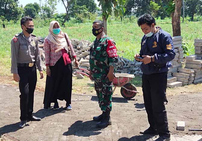 JALAN PENUNJANG PERTANIAN: Kepala Desa Wotgalih Rini Kusmiyati (dua dari kiri) memantau kegiatan pavingisasi di Dusun Karanganyar. (Foto: Istimewa)