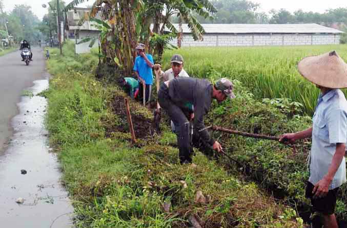 DIBERSIHKAN: Sejumlah warga melakukan normalisasi drainase di sisi Jalan Dusun Kalisat-Dusun Tanah Merah, Desa Lemah Kembar. (Foto: Pemerintah Desa Lemah Kembar for Jawa Pos Radar Bromo)