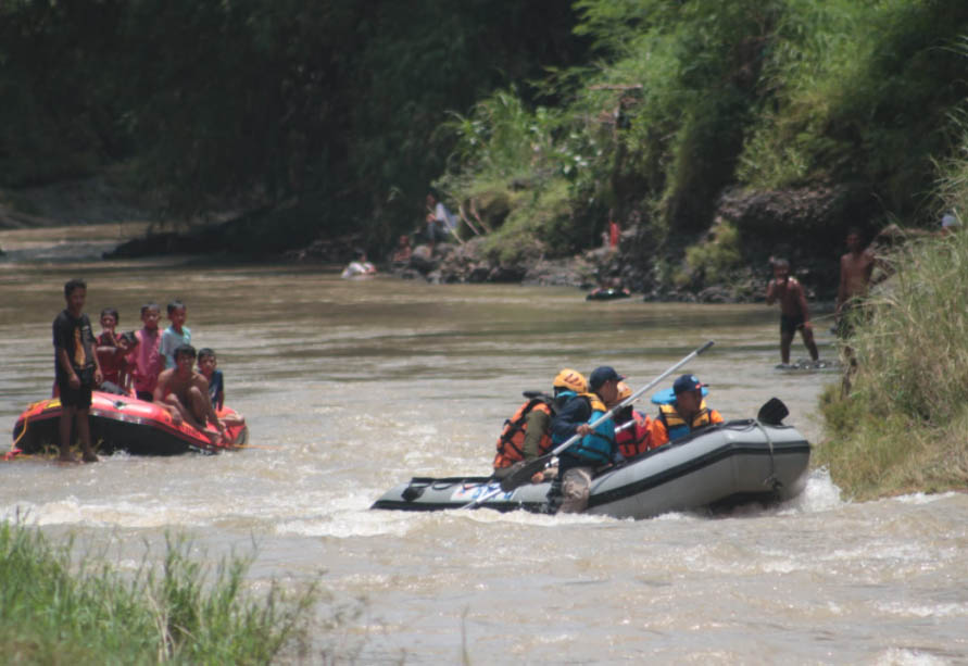 MASIH DICARI: Personel BPBD dan tim serach and rescue dengan perahu karet menyisiri Sungai Pakelan untuk mencari Rusdi. (Foto: Agus Faiz Musleh/Jawa Pos Radar Bromo)