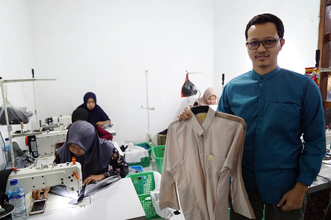 PANTANG MENYERAH: Gustiono Cahyani menunjukkan salah satu busana muslim buatannya. (M Busthomi/Jawa Pos Radar Bromo)