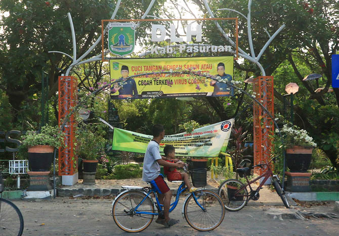PERLU PERHATIAN: Warga bersama anaknya melintas di hutan kota di Pogar, Bangil. Kabupaten Pasuruan masih berupaya untuk naik tingkat sebagai kabupaten layak anak. (Foto: M Zubaidillah/Jawa Pos Radar Bromo)