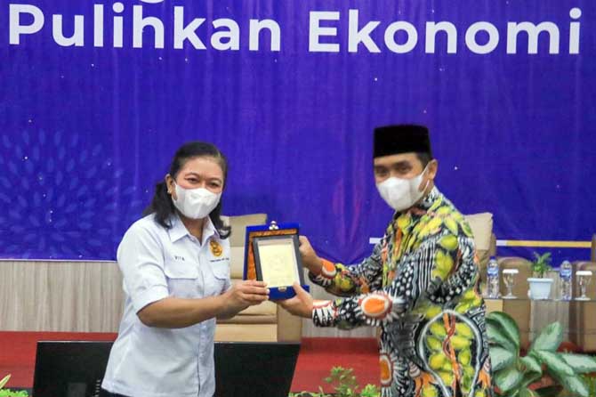 SERAHKAN PLAKAT: Kepala Kanwil DJP Jawa Timur III Agustin Vita Avantin (kiri) memberikan plakat kepada Wakil Wali Kota Pasuruan Adi Wibowo (kanan). (Mokhammad Zubaidillah/ Jawa Pos Radar Bromo)