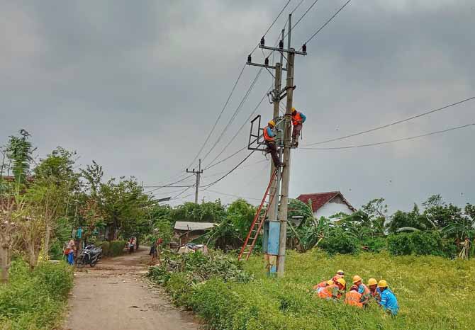 BENAHI JARINGAN: Petugas PLN membenahi jaringan listrik di Kecamatan Banyuanyar. Potensi listrik padam karena bencana masih terus dipantau PLN. (Foto: Achmad Arianto/Jawa Pos Radar Bromo)