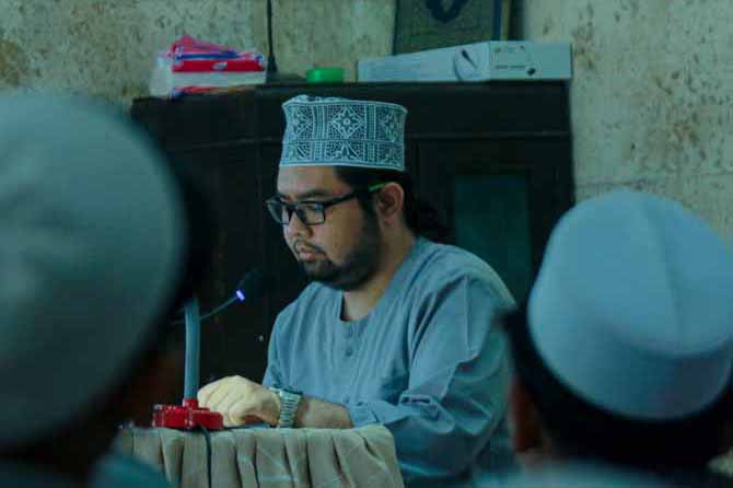 BERBAGI ILMU: Nun Hassan Ahsan Malik mengkaji kitab kuning bersama para santri di Pesantren Zainul Hasan Genggong. Kajian ini juga disiarkan secara live melalui akun media sosial Pesantren Zainul Hasan Genggong. (Foto: Agus Faiz Musleh/Jawa Pos Radar Brom