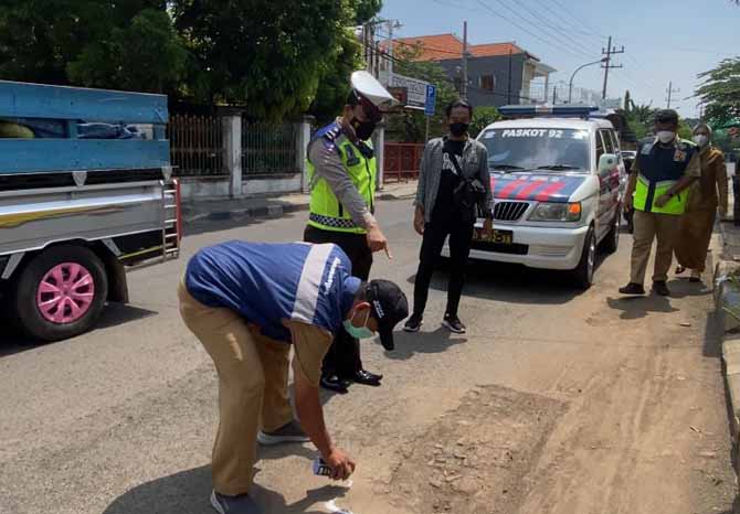 MASIH RUSAK: Petugas menyurvei kerusakan jalan bekas galian jargas. (Foto: M Rosyidi/Jawa Pos Radar Bromo)