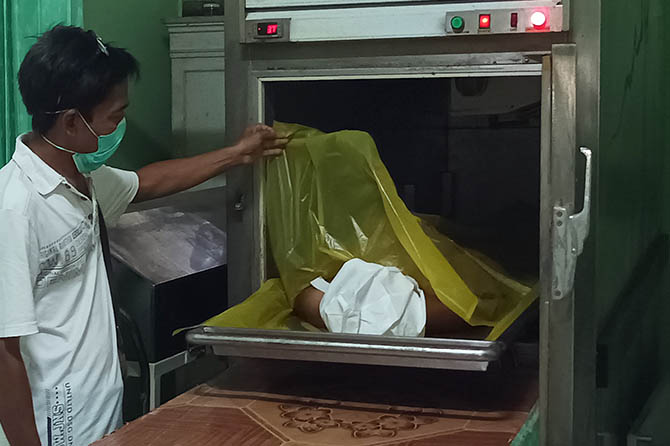 ASAL PLAMPANG: Seorang petugas memeriksa jenazah Dedi Hariyanto, ketika masih berada di kamar mayat RSUD Waluyo Jati, Kecamatan Kraksaan, Jumat (20/5). (Dok. Radar Bromo)